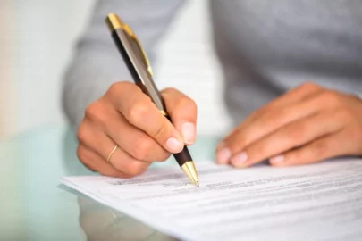 Close-up of a person's hand signing a document