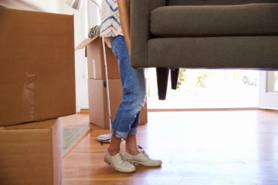 woman carrying the end of a couch
