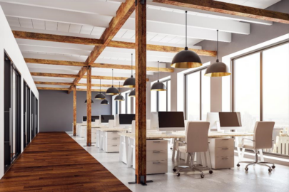 A clean, open office space with white desks, computers, and white desk chairs.