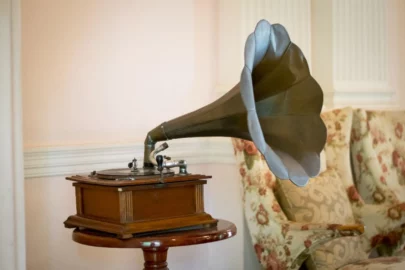 An antique record player with horn sitting on a side table.