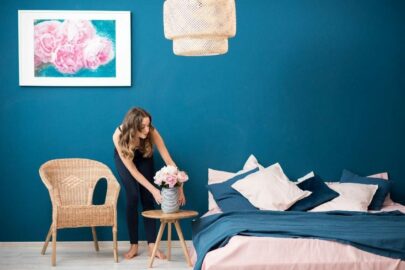 Woman decorating in blue bedroom.