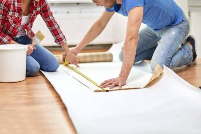 Two people measuring wallpaper.