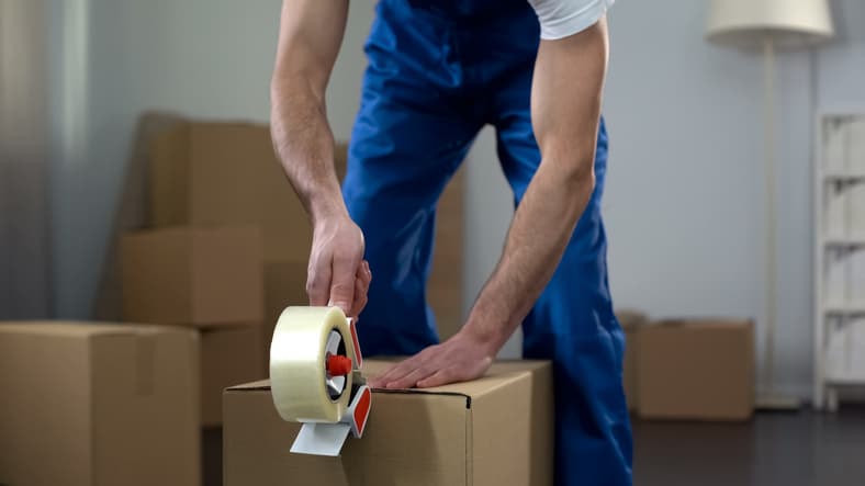 A storage professional taping a box closed.
