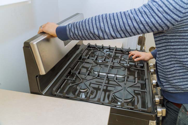 A man disconnecting his gas stove.