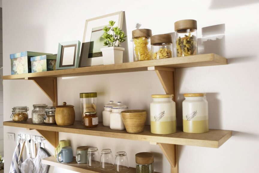 A wooden shelf displaying many kitchen objects.