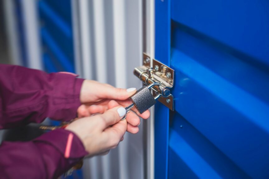 A person unlocking a self storage unit, which is the process of keeping and storing belongings and items in a storage unit.